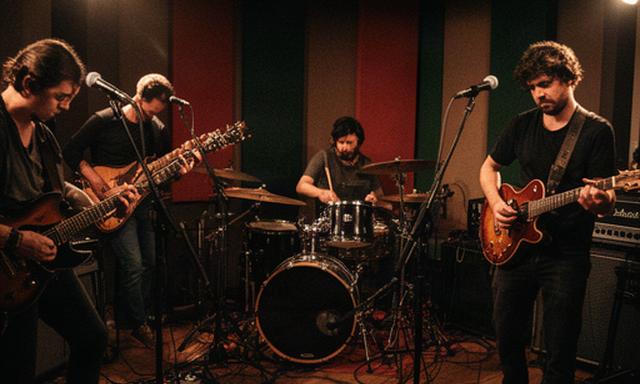 Banda local grabando guitarras y batería en una sala acústica de Valencia